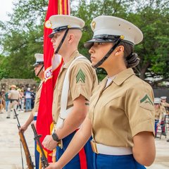 Three marines standing at attention to the side outside of Alamo Church