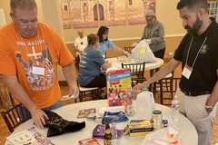 Two men standing around a round table looking at packaging materials