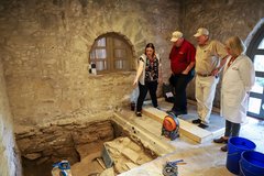 Alamo archaeology and conservation experts inspect an excavation unit in the Long Barrack.