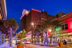 Night view of Maverick Hotel on Houston Street with trees wrapped in colorful lights
