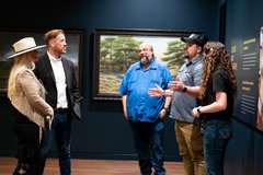 Guests discussing artifacts with museum staff in a gallery