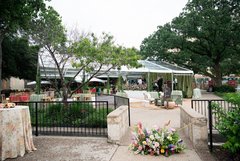 Florals on walkway entrance to a tent in Alamo Gardens set up for an outdoor event