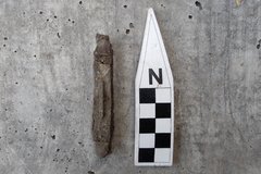 Rusty pocket knife next to a ruler for size