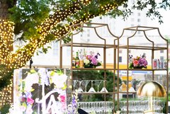 Spring florals and martini glasses set on glass shelves of an outdoor bar