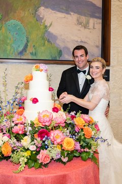Bride and groom cutting the tiered wedding cake, surrounded by Spring flowers