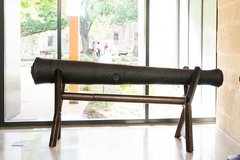 Historic 16 pound cannon on a stand inside next to a window