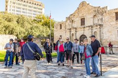 Group of people listening to a tour guide in front of Alamo Church