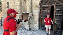 Tour guide leads a live streamed tour of Alamo Church