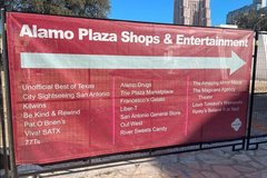 Red banner with arrow to show direction of Alamo Plaza Shops and Restaurants